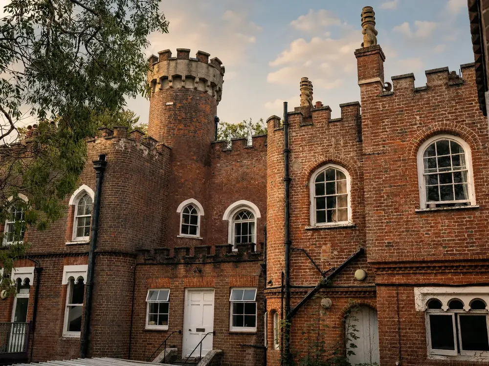The crenellated towers of Belmont Castle in warm evening light